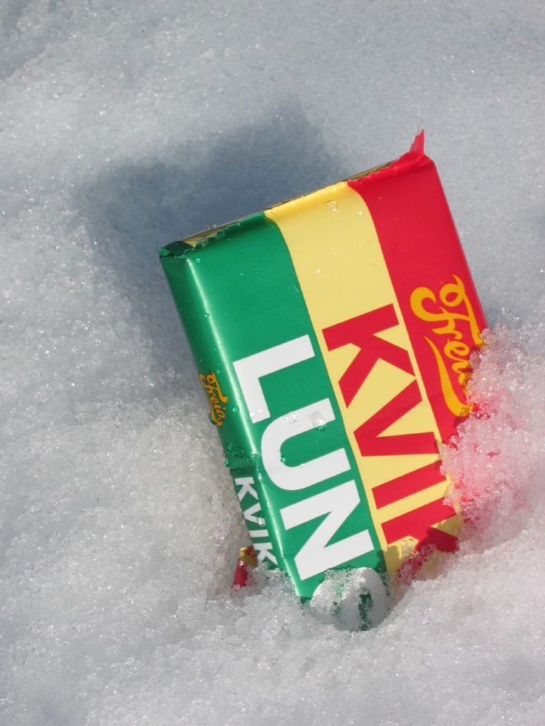 A Norwegian chocolate bar, "Kvikklunsj", lying serenely in the snow. Photo.